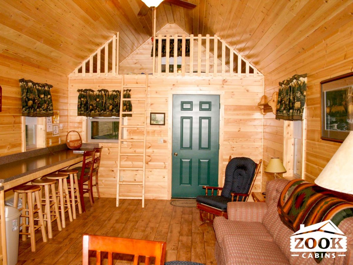log cabin ineterior with green door and loft above front door