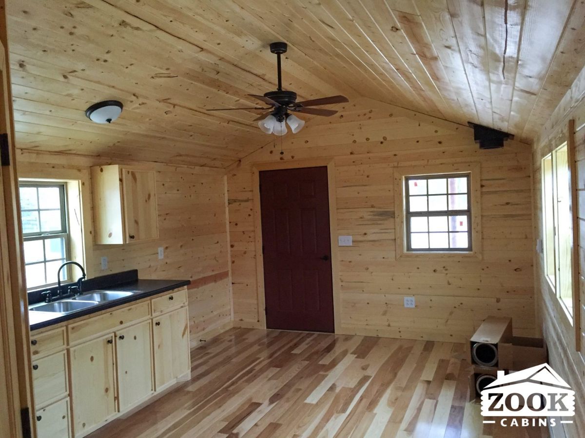 basic wood intererior of tiny home style cabin with kitchen on left of image