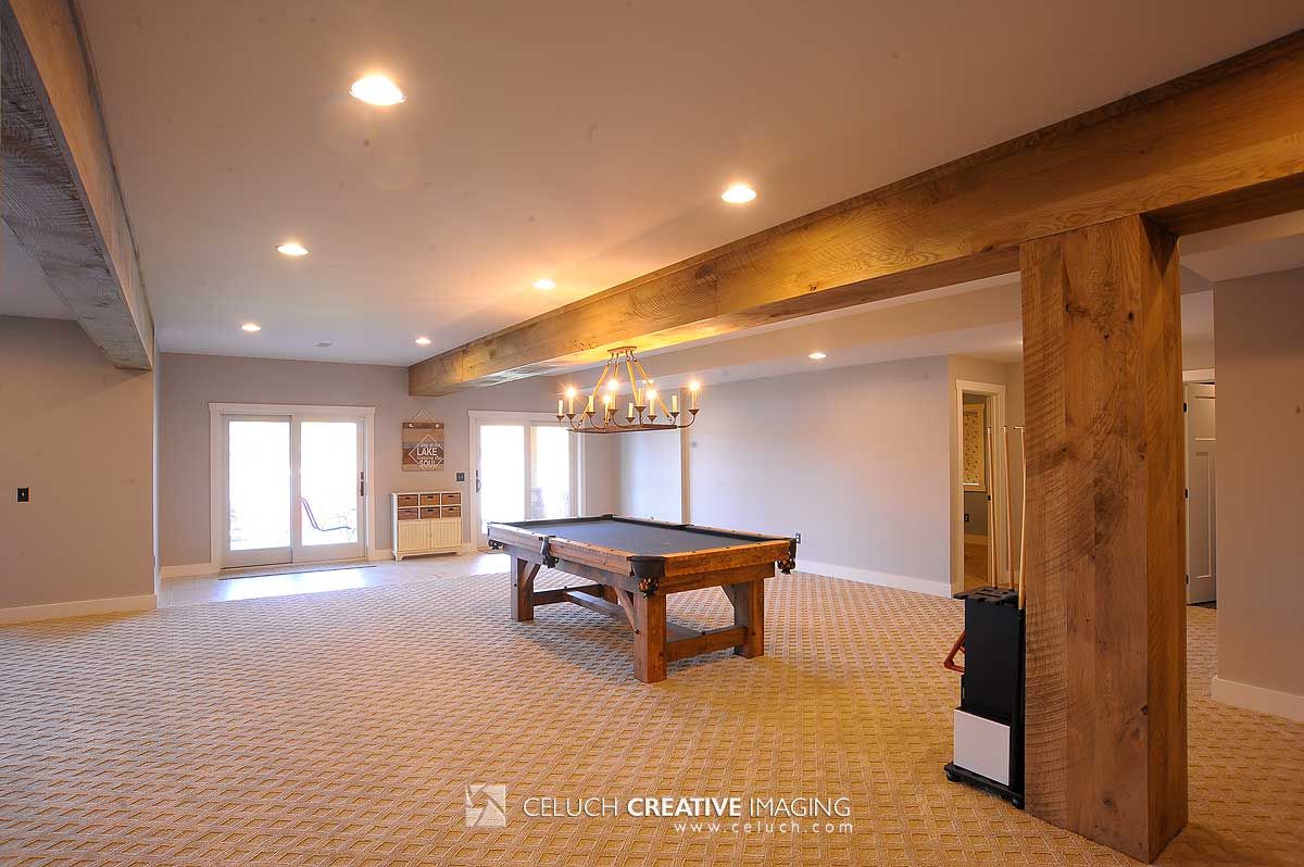 pool table in open basement with windows on far left