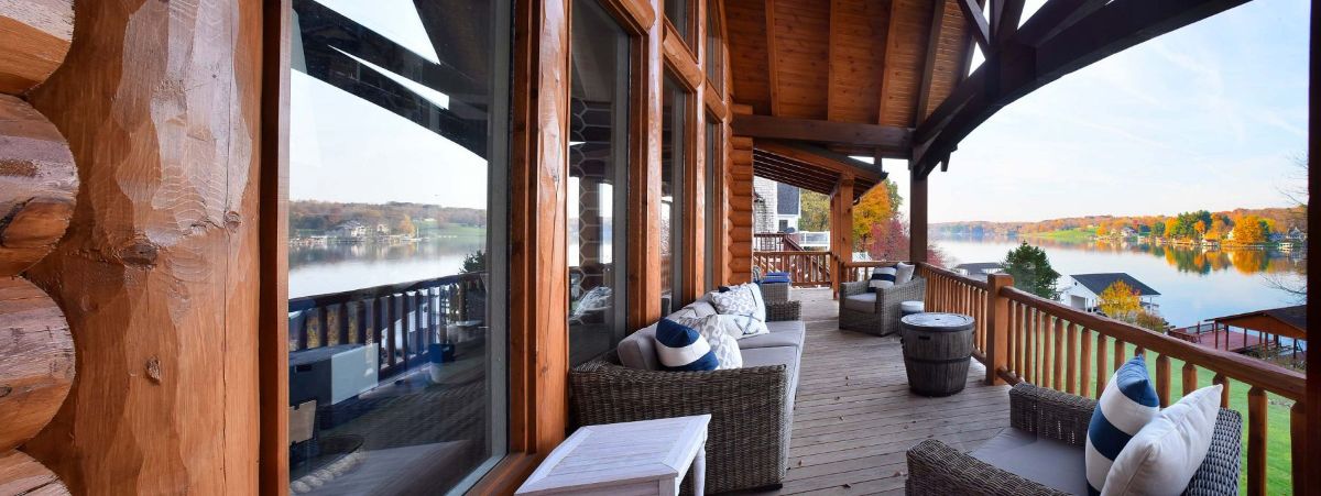 gray sofa on covered deck with view of lake in background