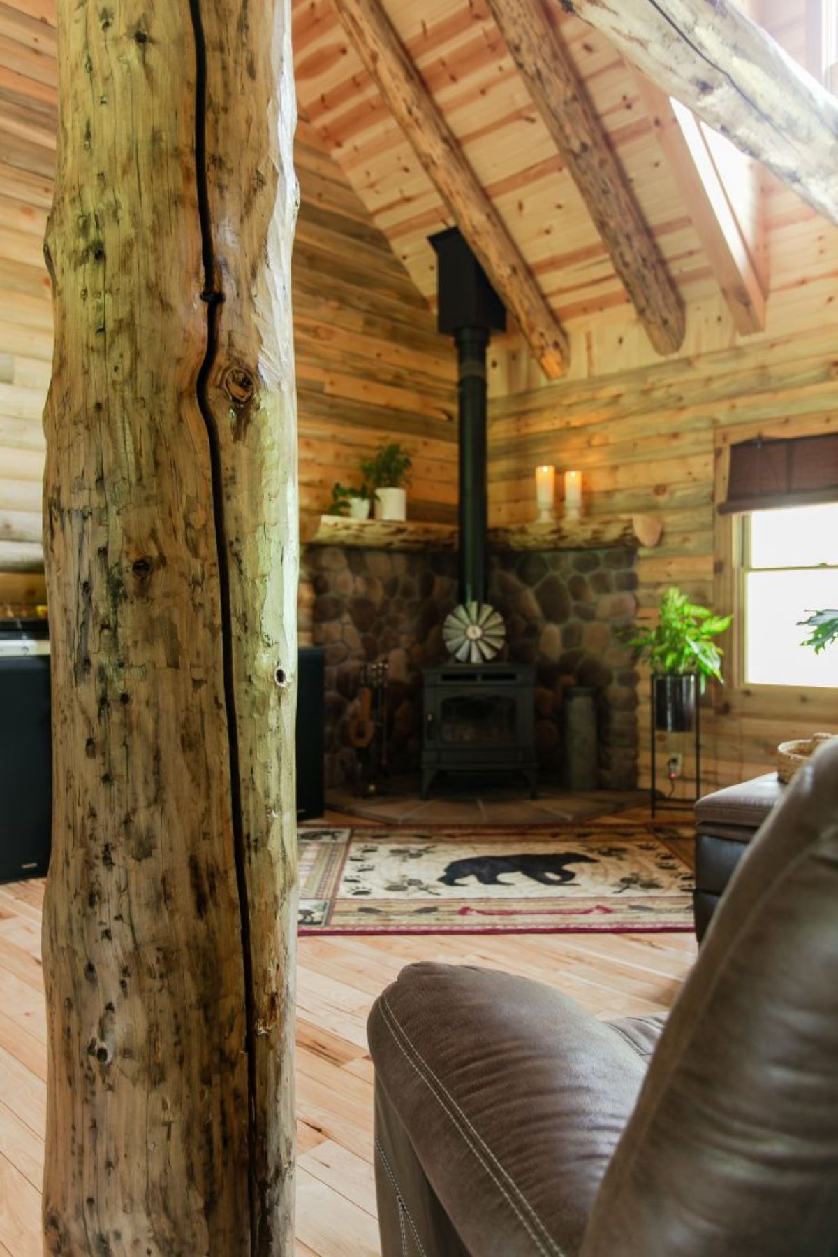 black wood stove against wall with wood beam in foreground