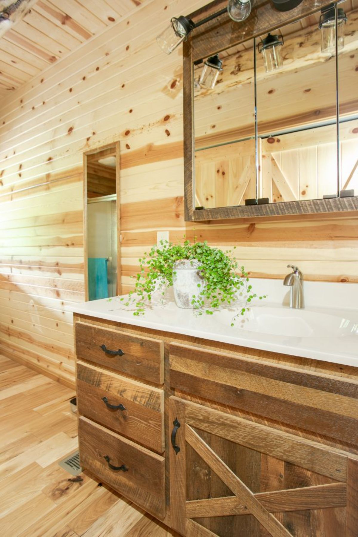 wood cabinet with whtie sink and floor length mirror on side