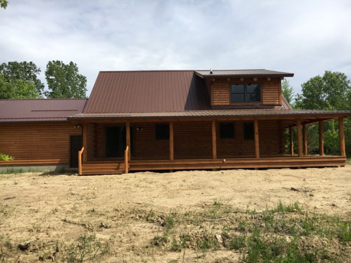 side of log cabin showing covered porches