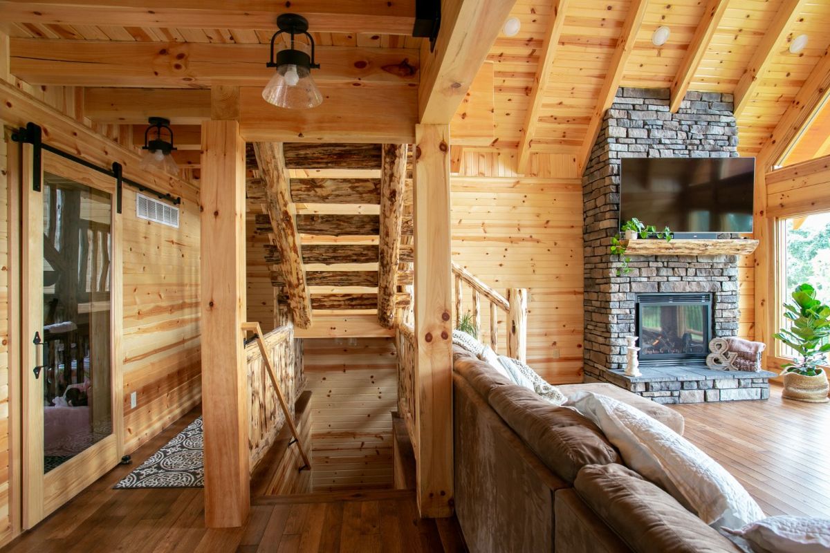 view underneath stairs in living room with sofa and fireplace on right