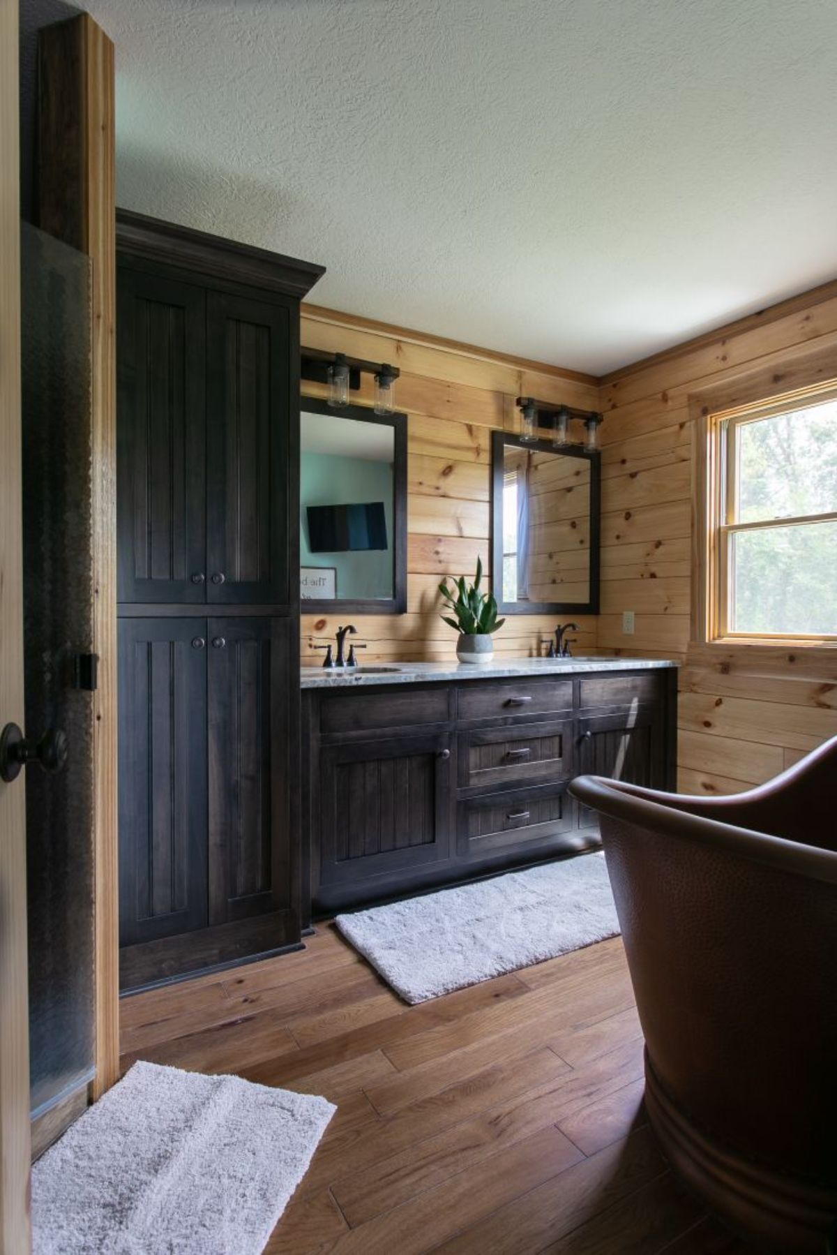 view into bathroom from door showing dark wood cabinets against left wall