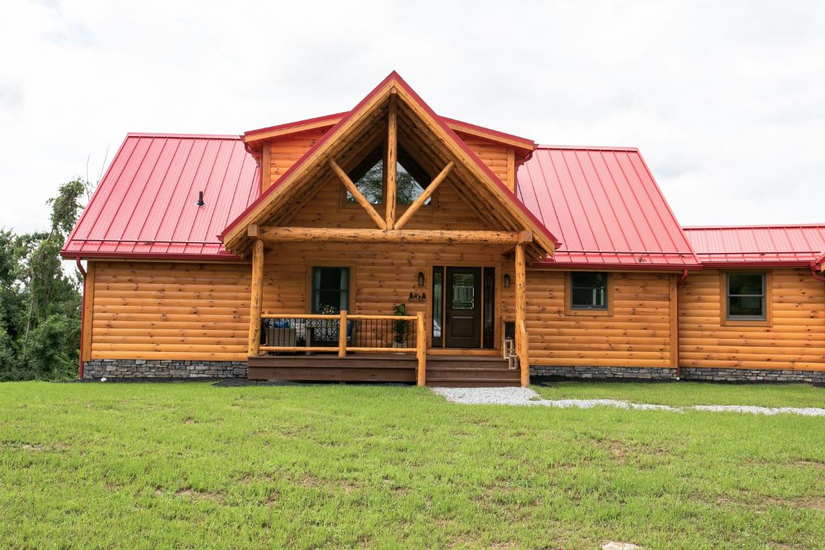 front of log cabin with covered small porch and red roofline
