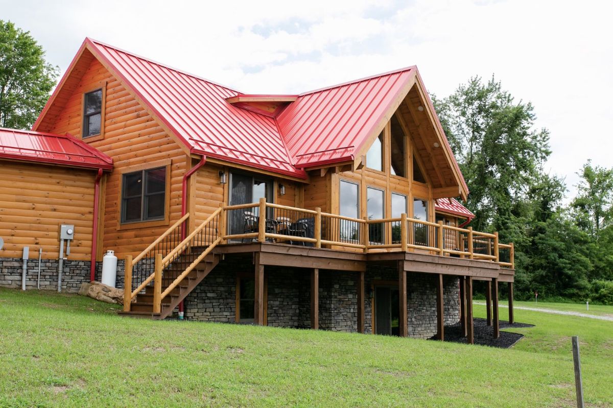 side of log cabin on hill with open deck and walkout basement