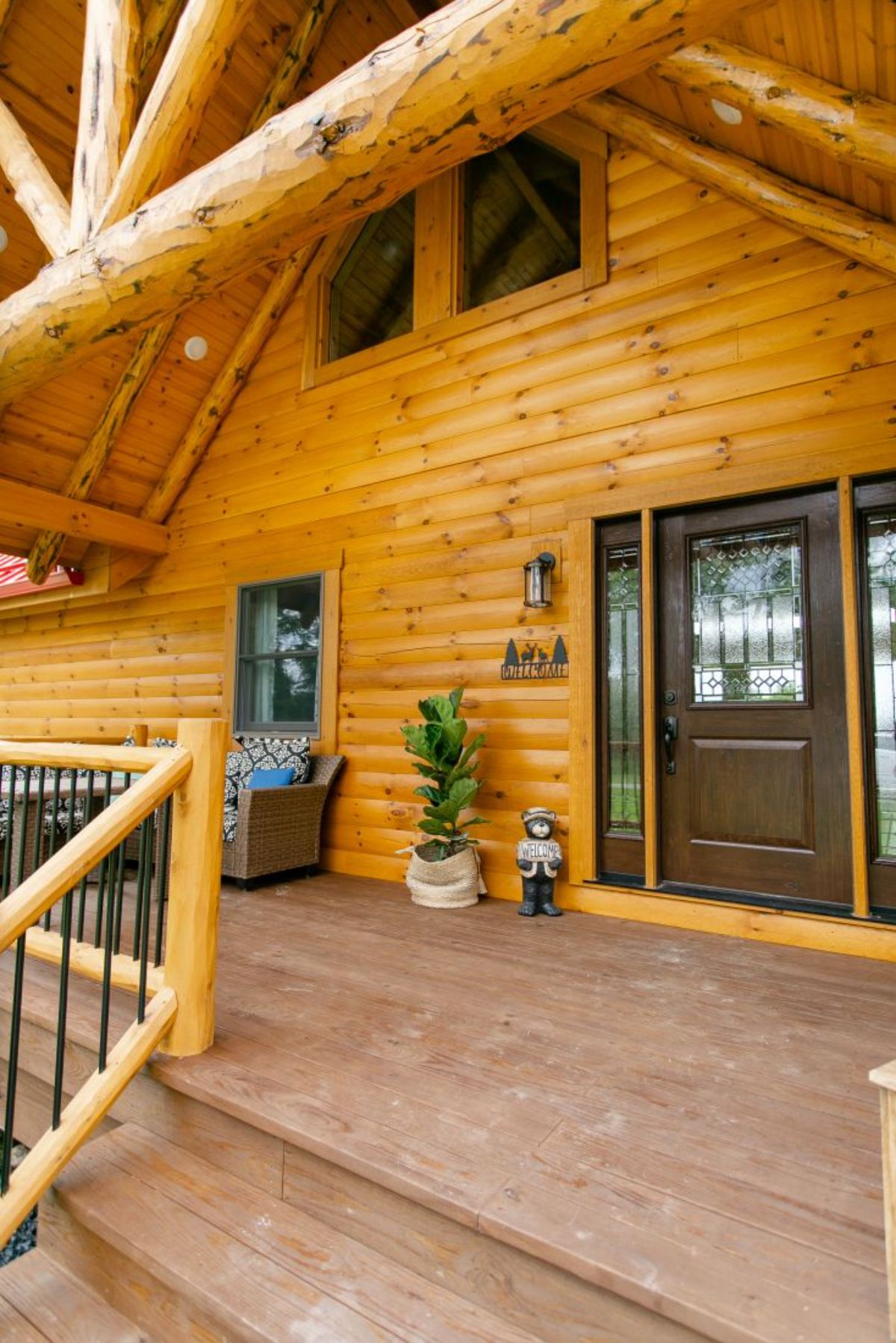 brown doors with side glass panels on log cabin porch