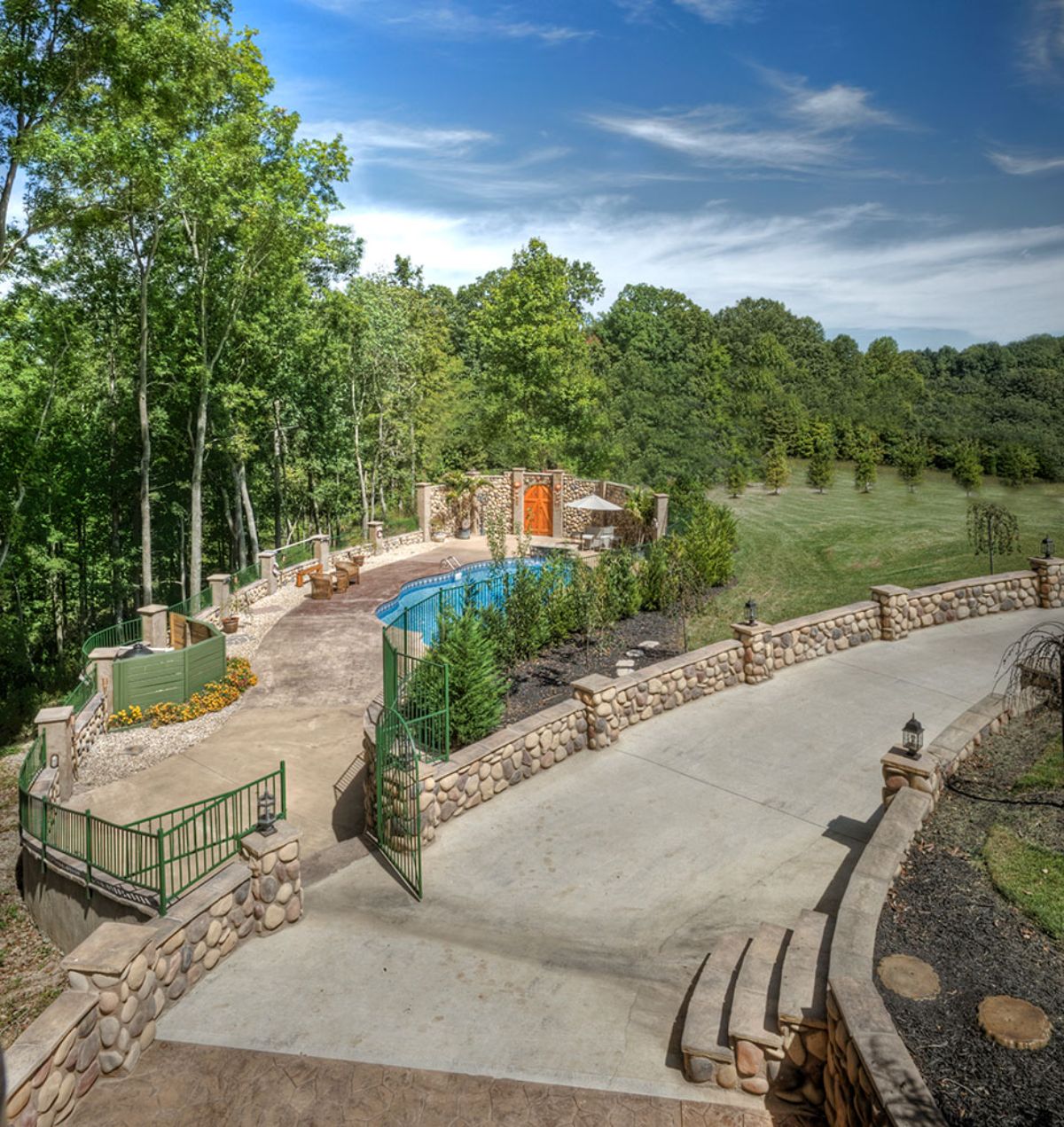 concrete walkway on back of home with pool on left