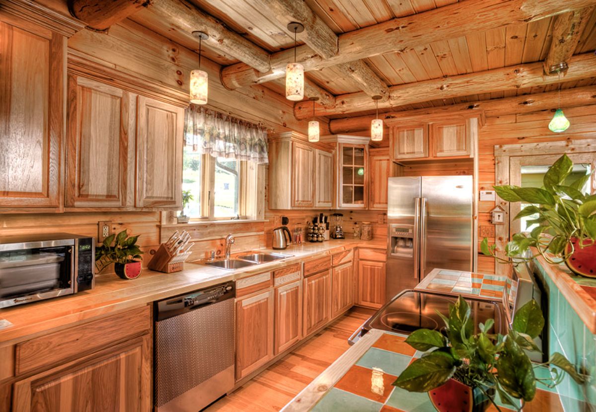 light wood cabinets in log cabin kitchen with stainless steel appliances