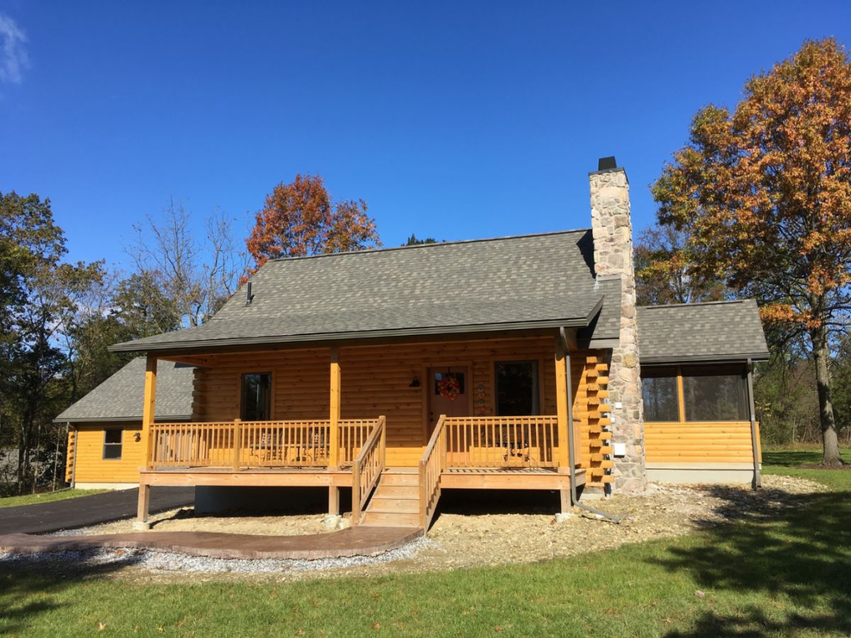 log cabin with light wood and green roof