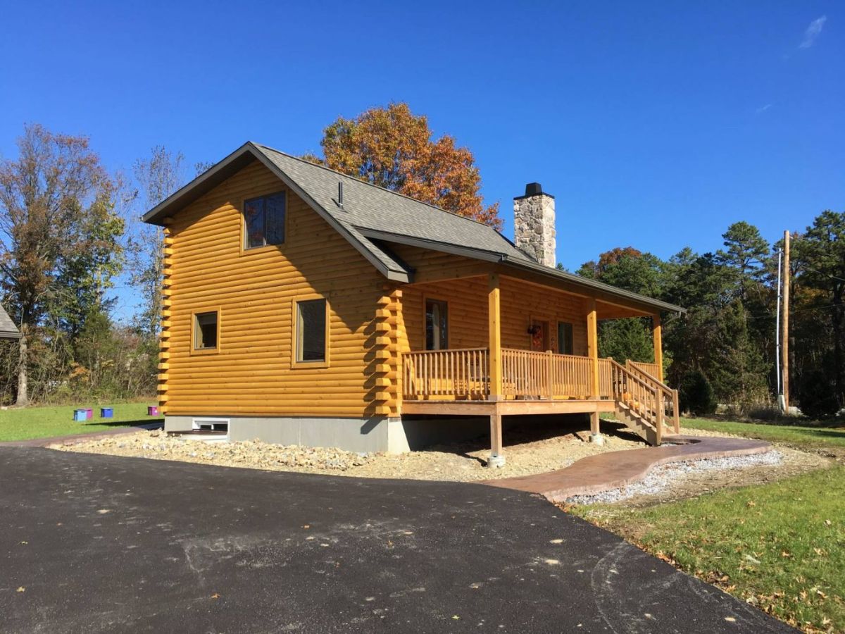 side of log cabin by asphalt driveway