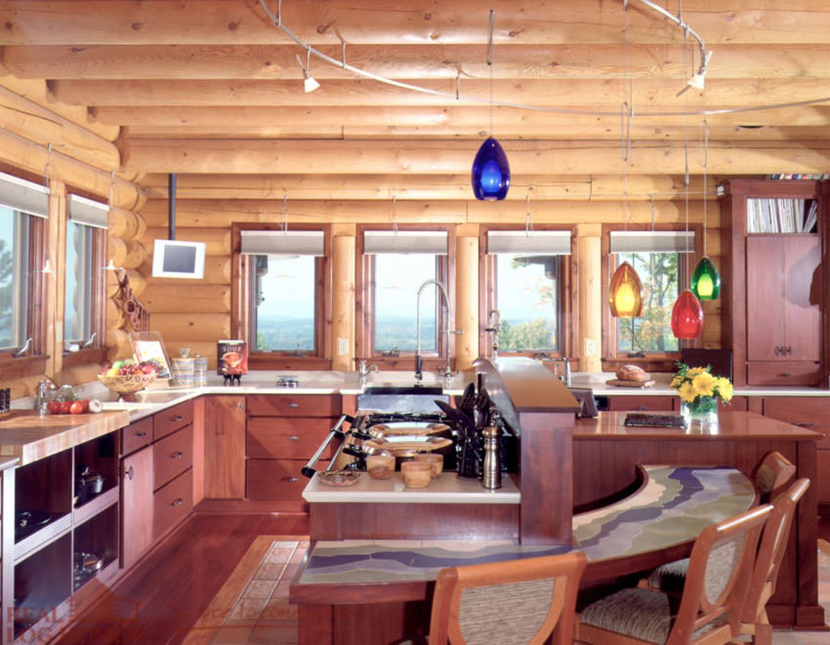 kitchen with dark wood cabinets against light wood walls with windows on back