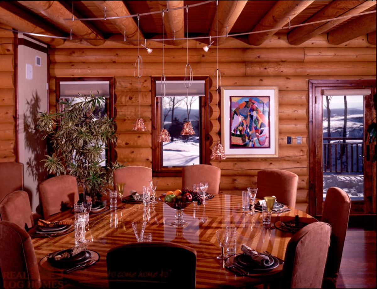 art on wall by window in dining room of log cabin