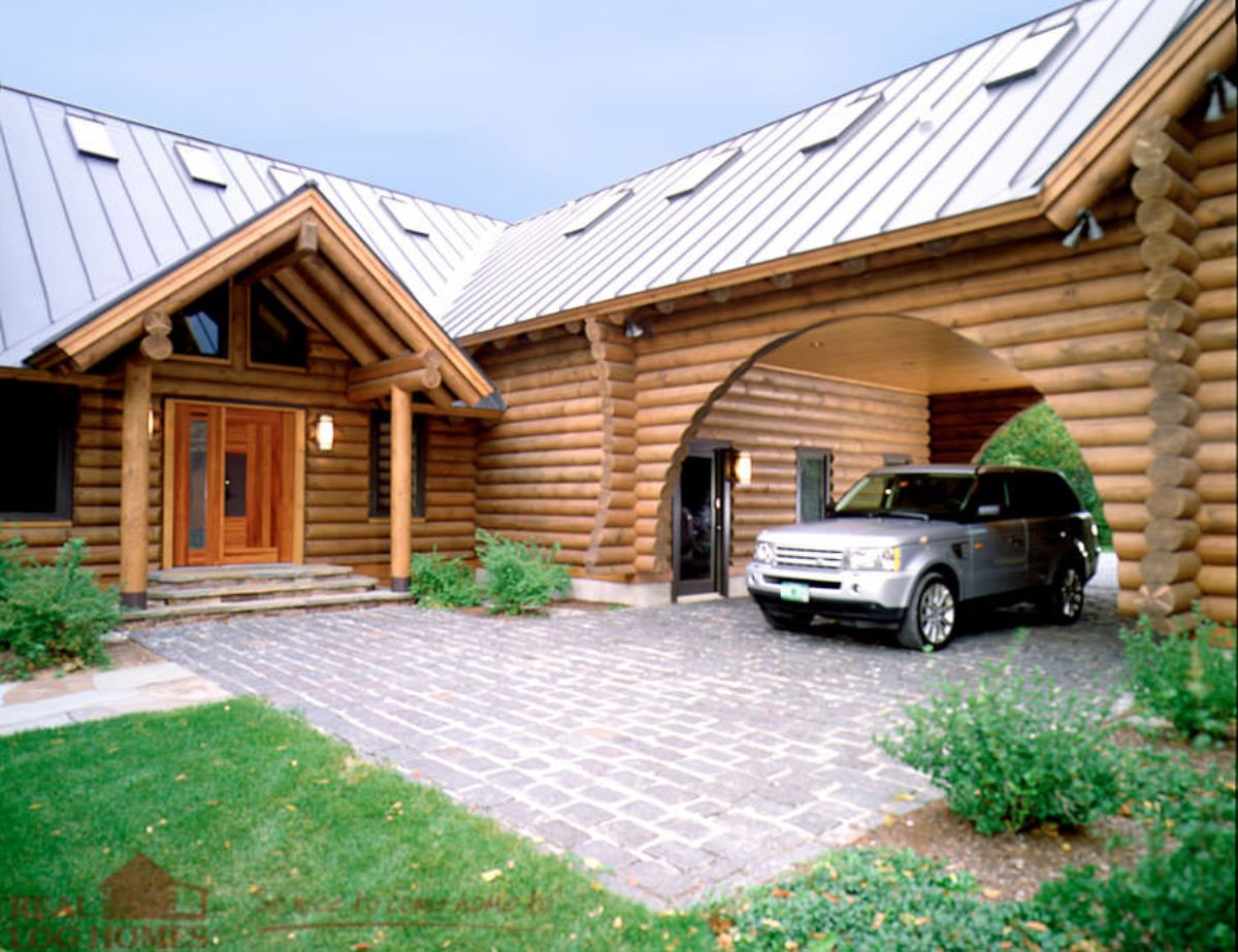 gray suv in carport of log cabin