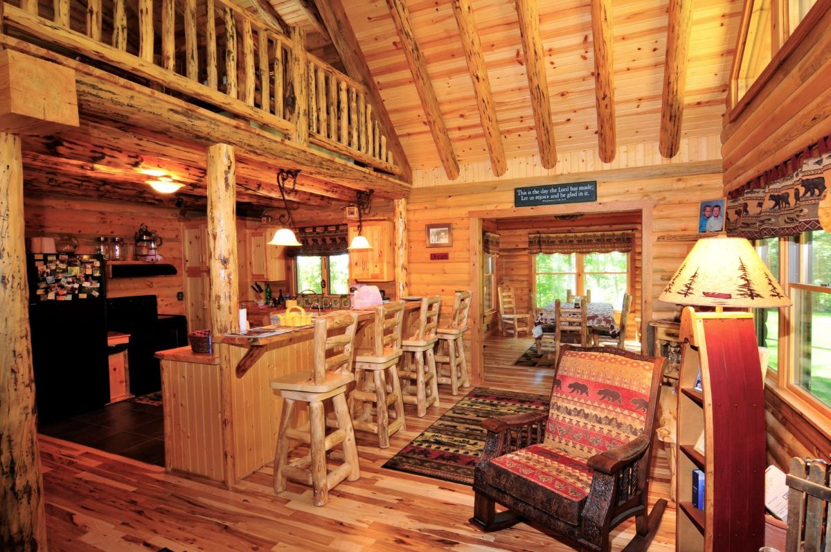 view across main floor of home with open doors in background and rustic chair to right