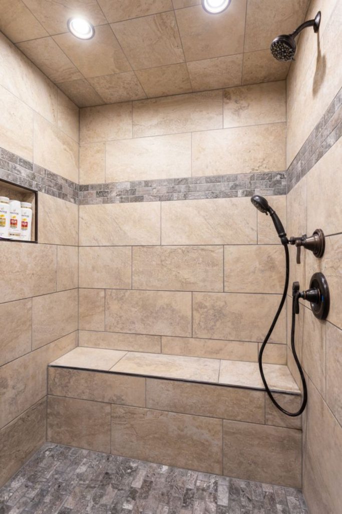 light cream and gray tiled shower with bench seat
