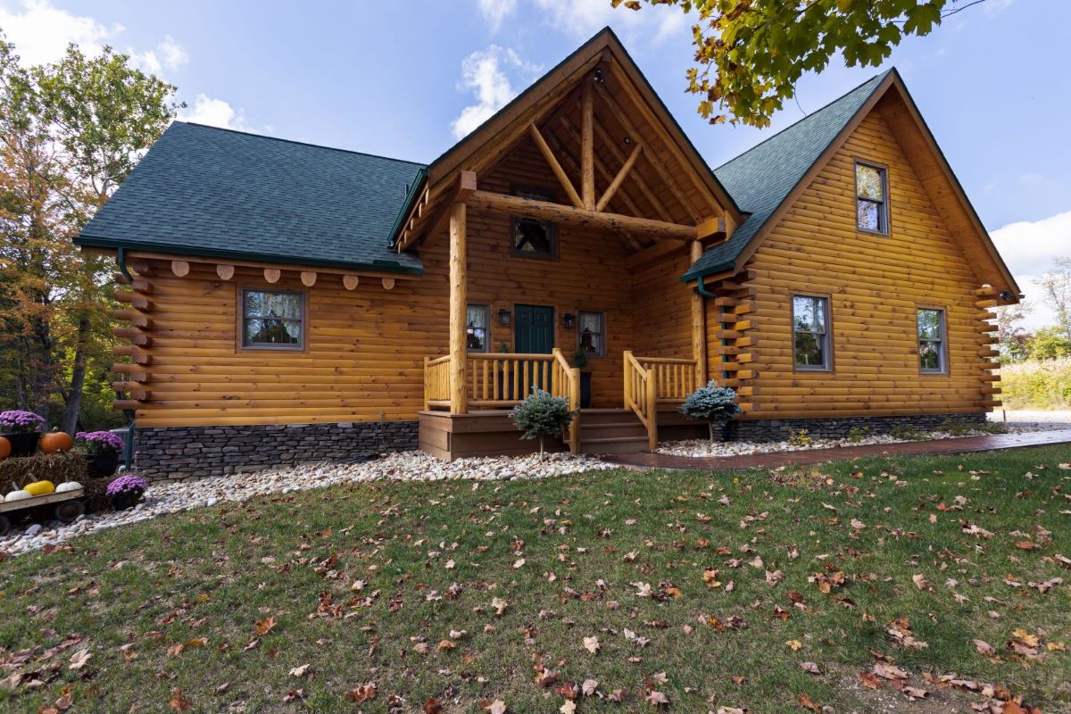 front of log cabin with light wood stain and small porch at front door