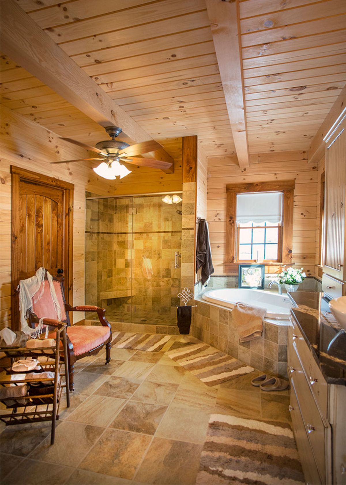 tiled shower next to soaking tub in log cabin bathroom