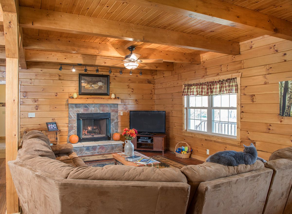 view across light brown sofa toward fireplace in corner