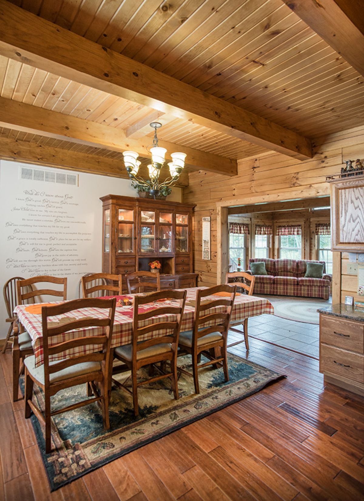 dining table over rug in dining room with white wall and dark wood hutch in background