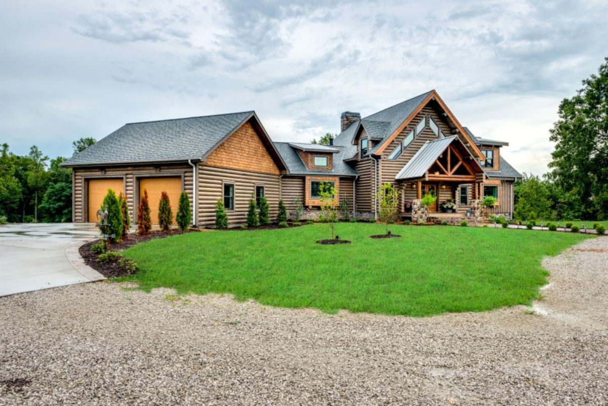 gravel driveway with grass yard in front of cabin