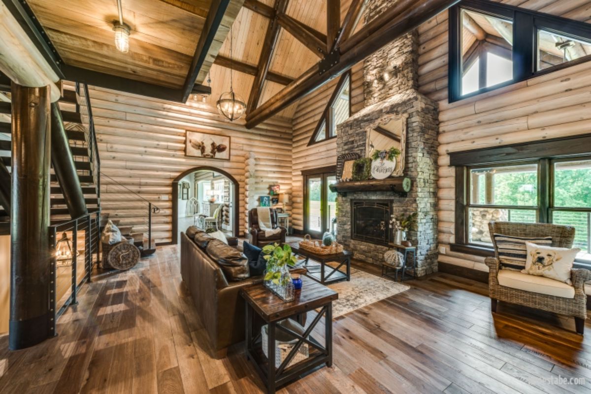 stone fireplace in log cabin with sofa in front
