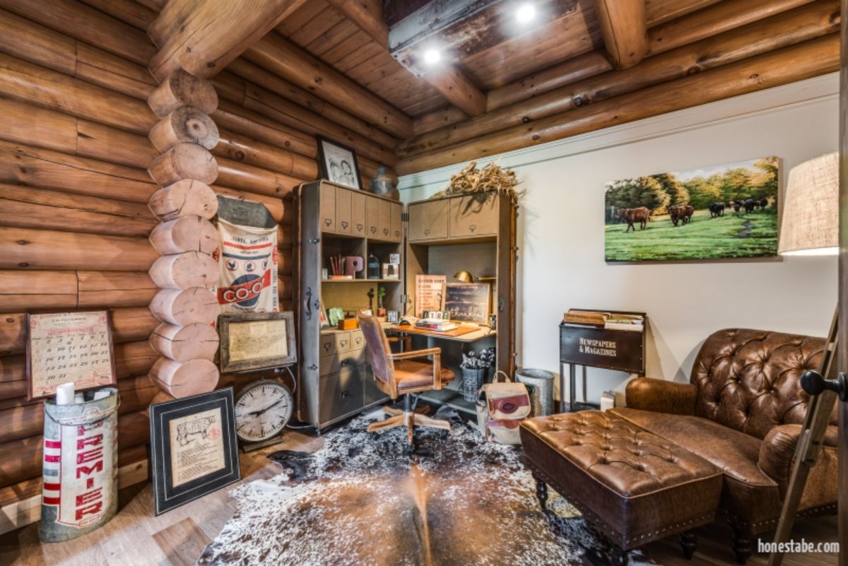 corner desk in log cabin with white wall on right and logs on left