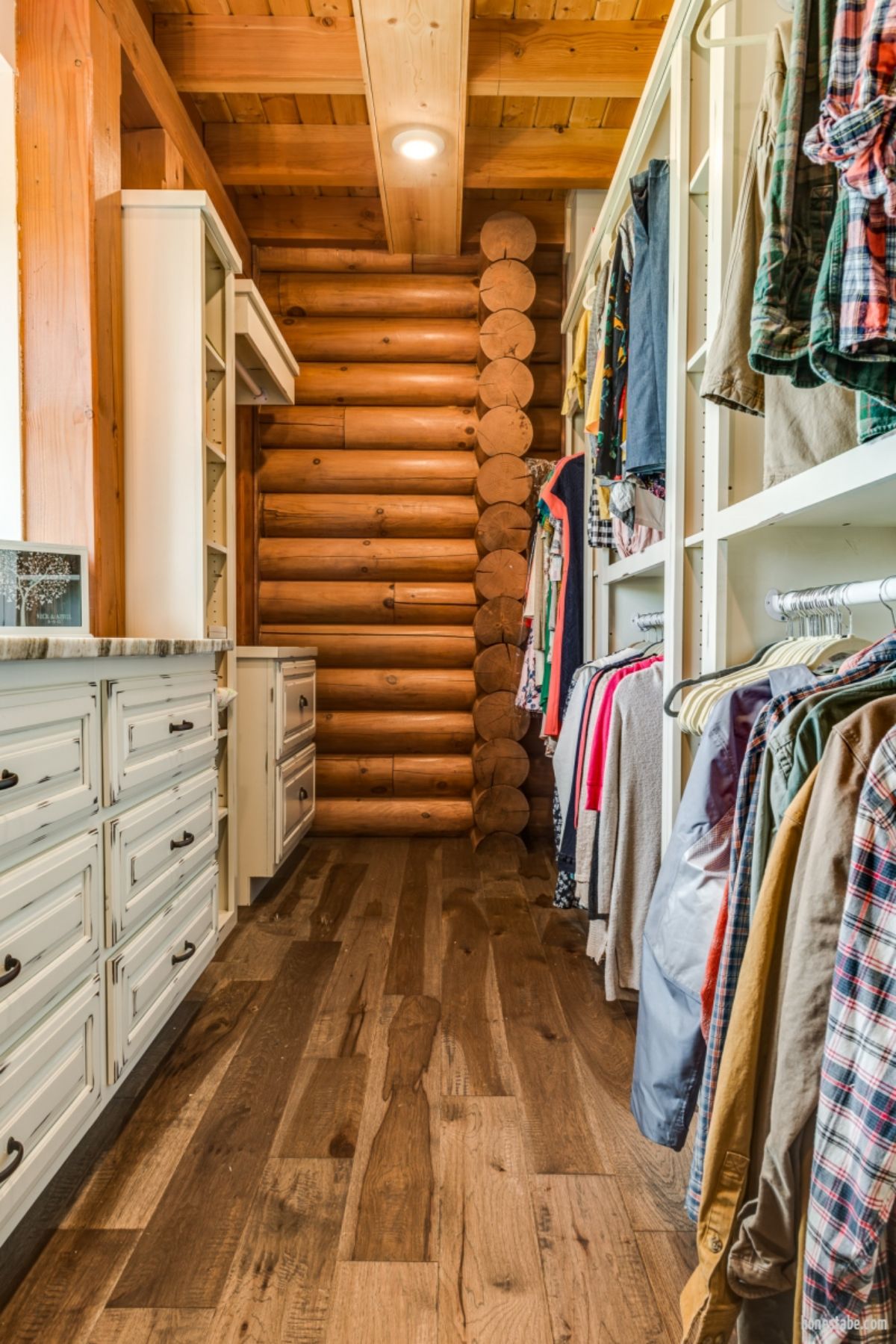 closet with racks of shirts on right and log background