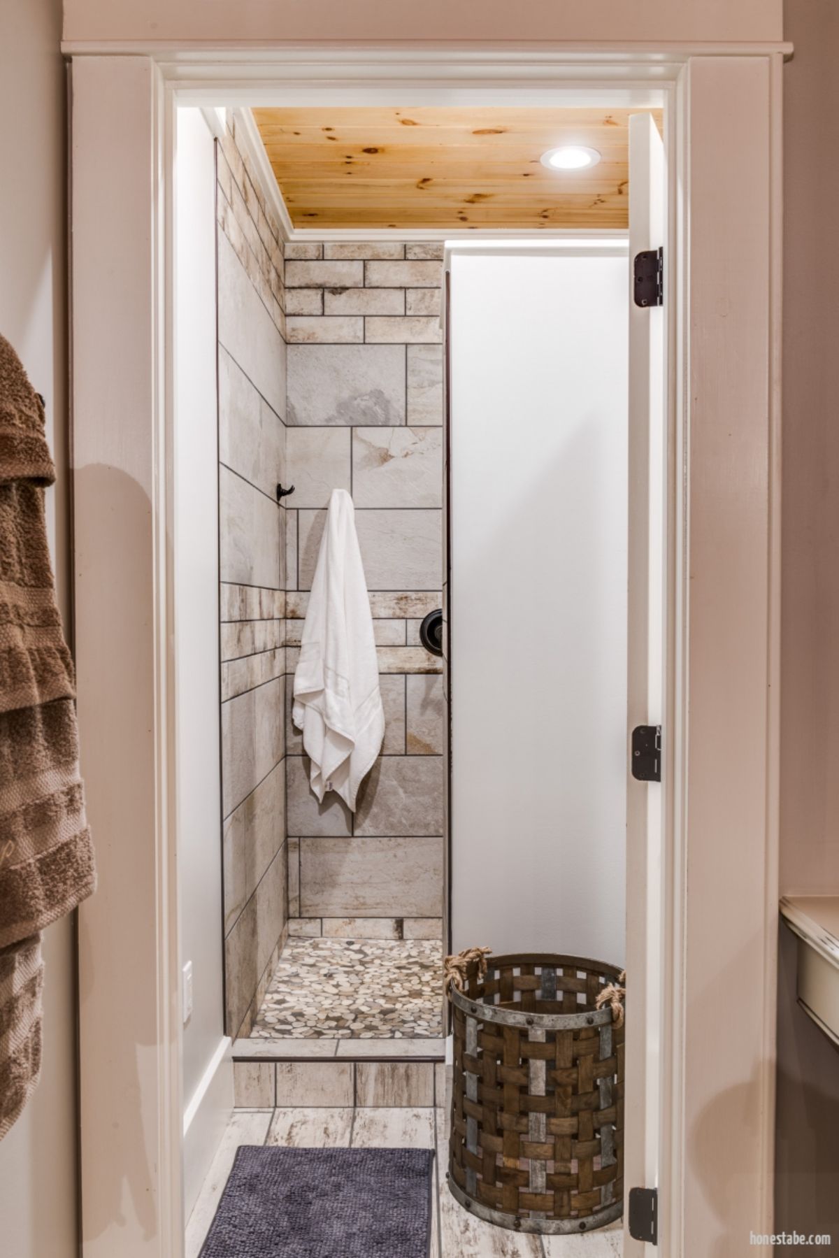 tiled shower stall with white towel hanging