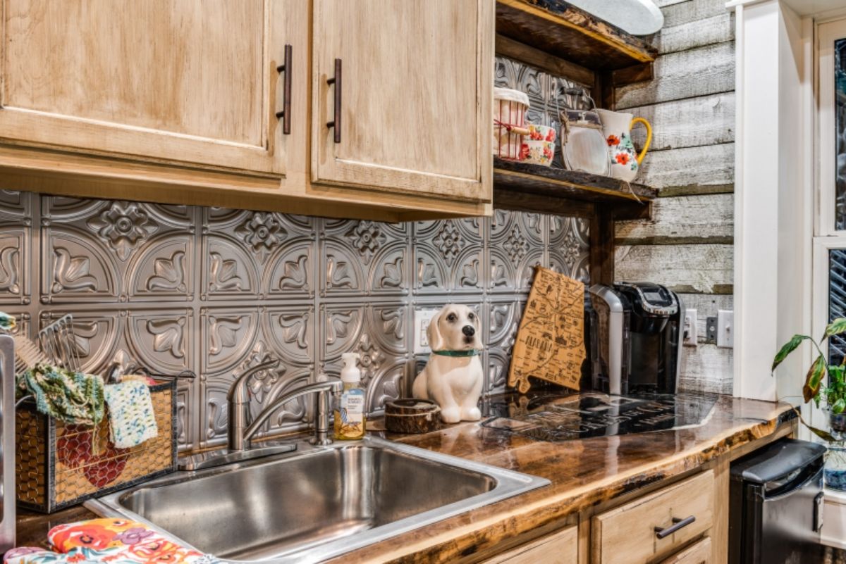 chrome backsplash in kitchen with light wood cabinets