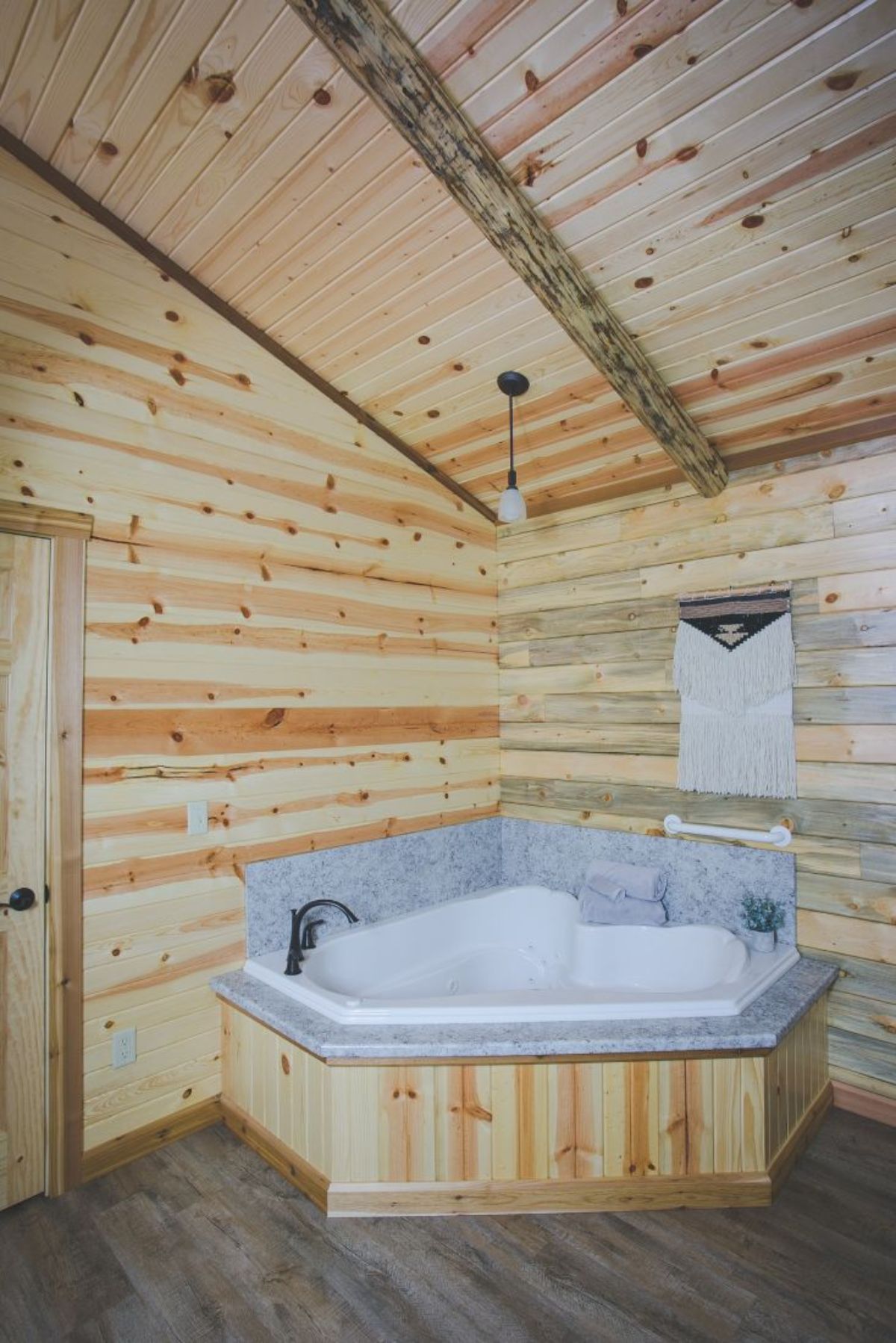 corner Jacuzzi bathtub with white tub and gray tile surround