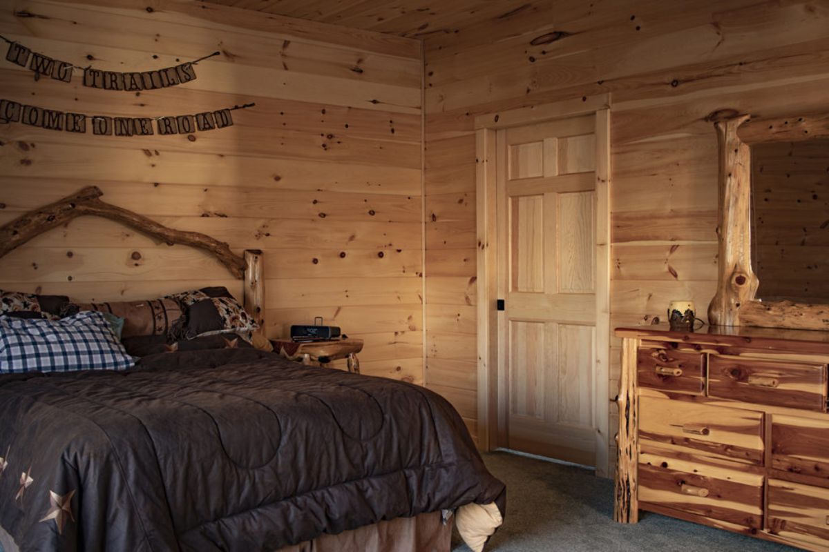 black bedding on bed in log cabin bedroom