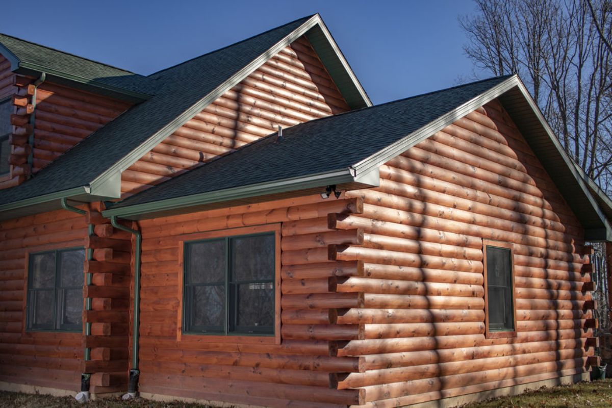 side of log cabin with two windows