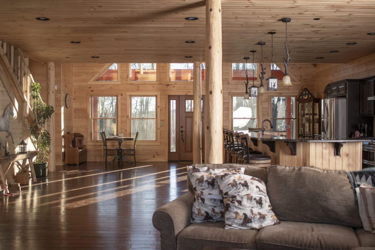 view across log cabin to front door behind brown sofa