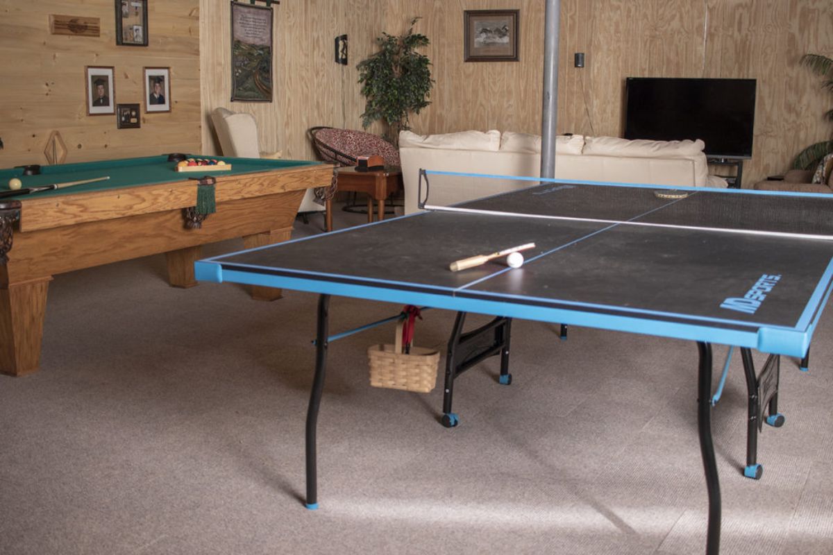 pool table and ping pong table in room behind white sofas