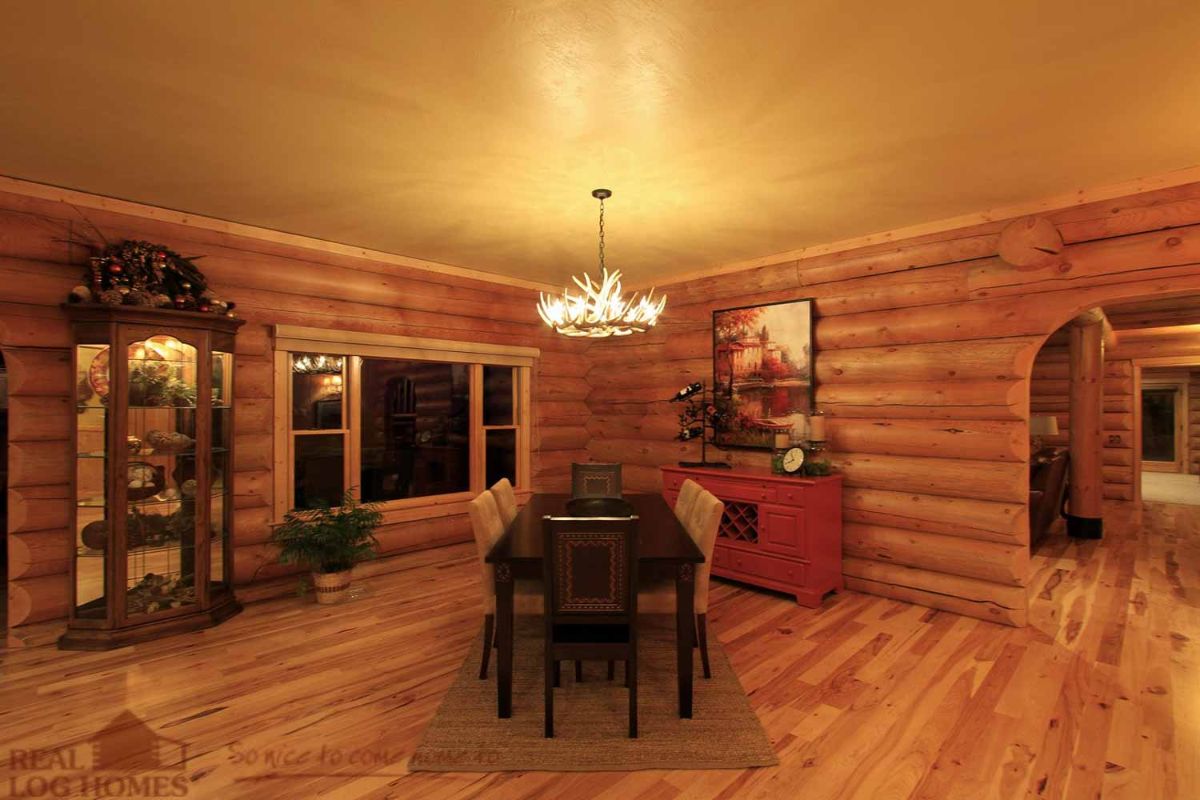 dining table in corner of log cabin with windows on left