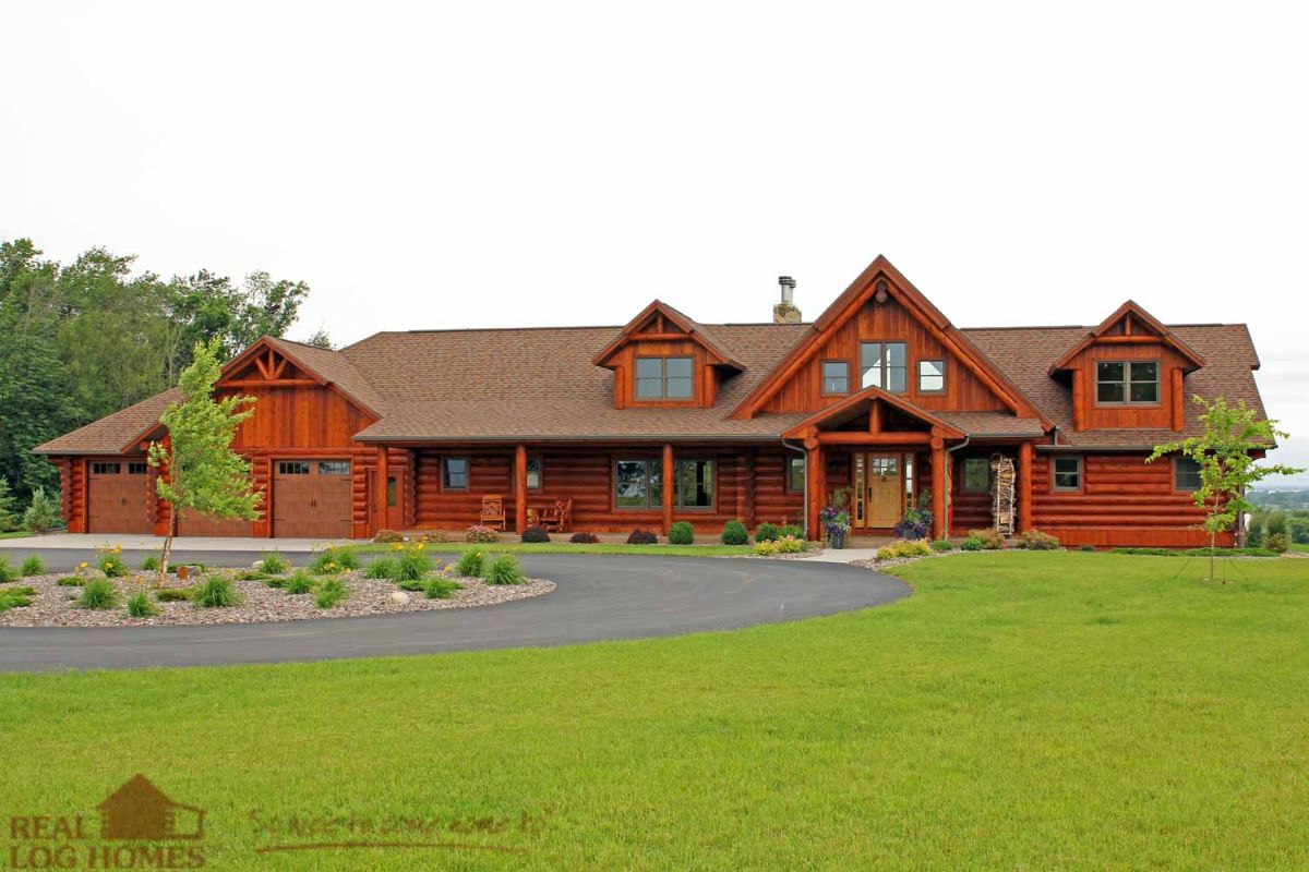 log cabin with asphalt driveway and grass in yard