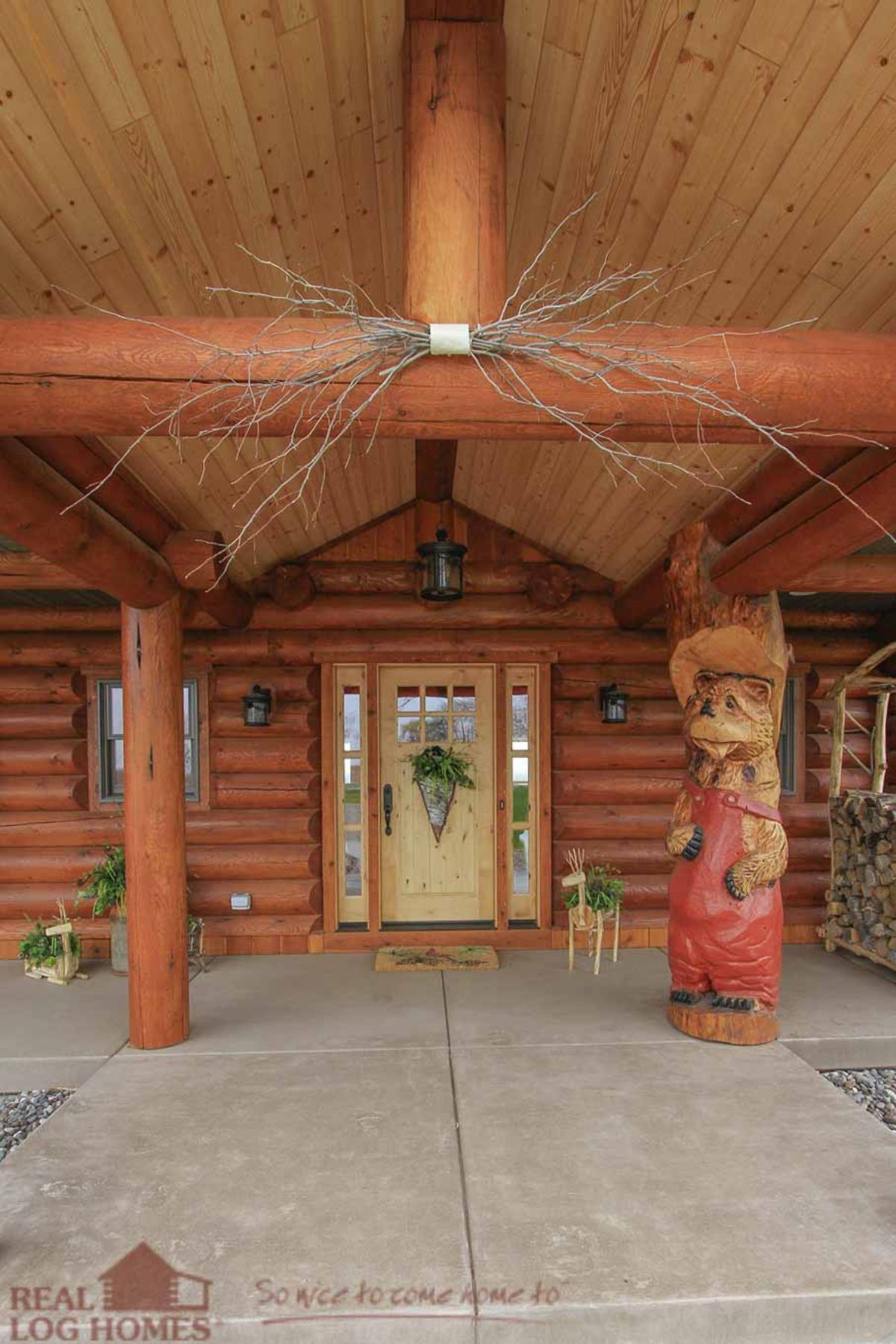 front door to the log cabin with a unique bear carving as a column support