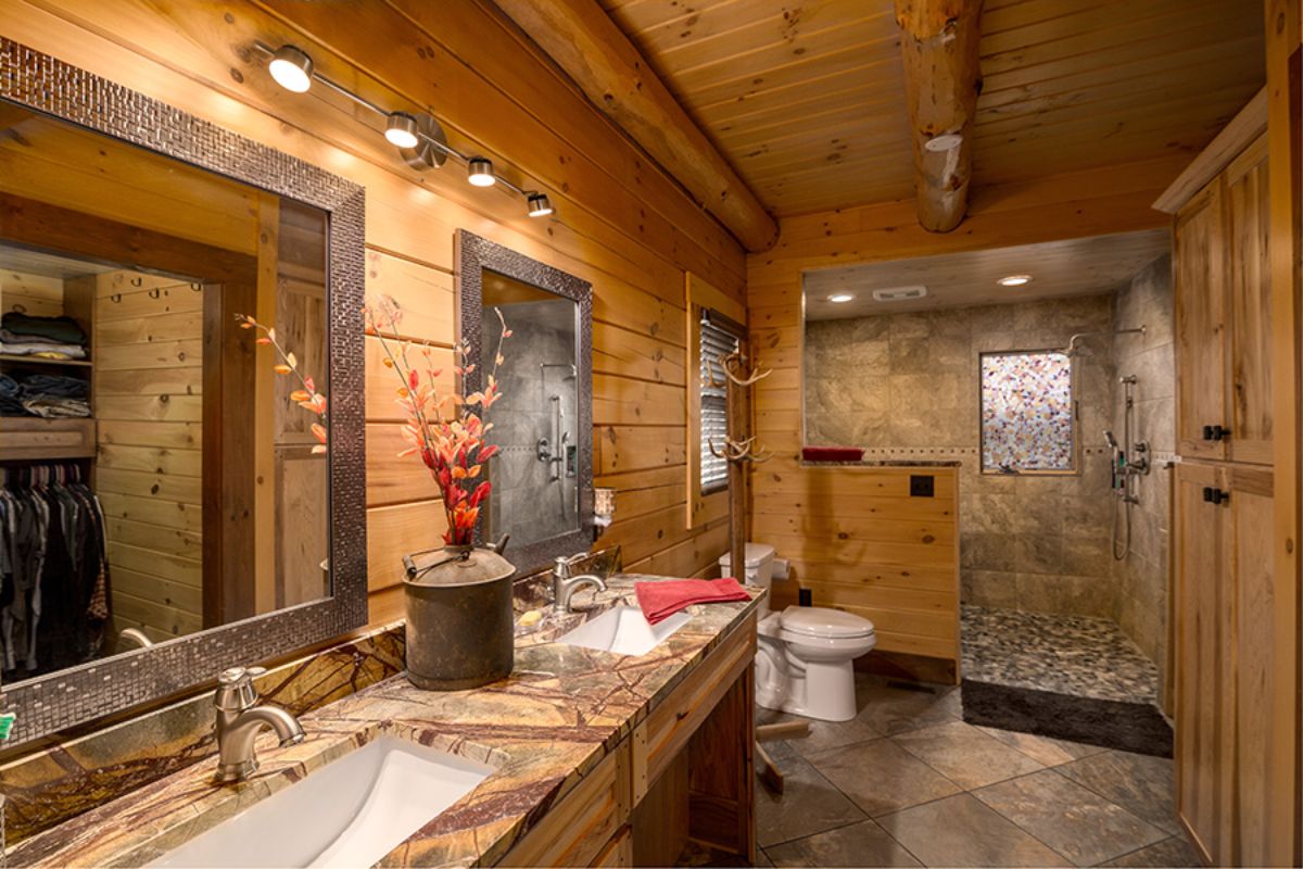 tile shower behind toilet in master bedroom of log cabin