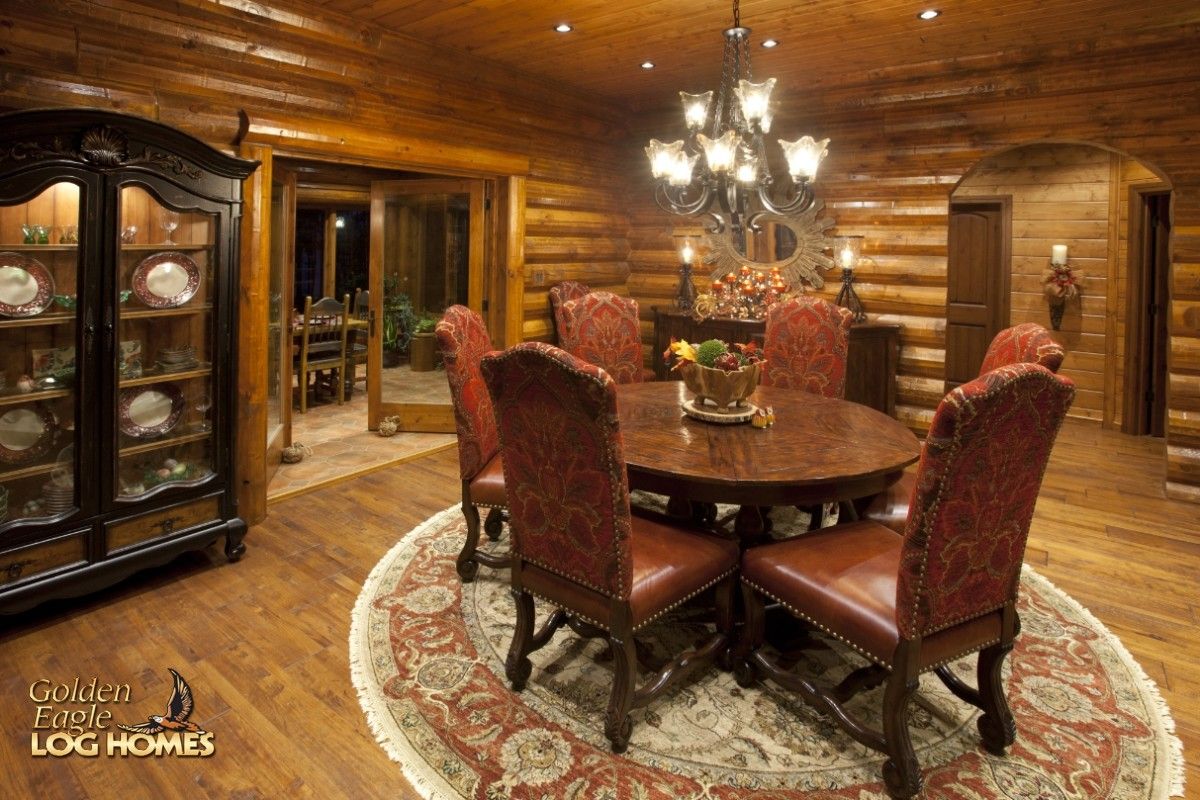 round table with red upholstered chairs on top of floral rug in dining room