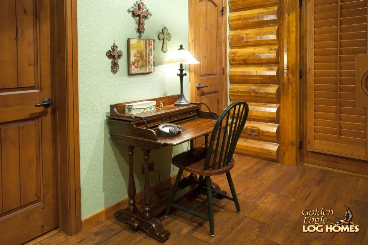 writing desk against green wall between two wood doors