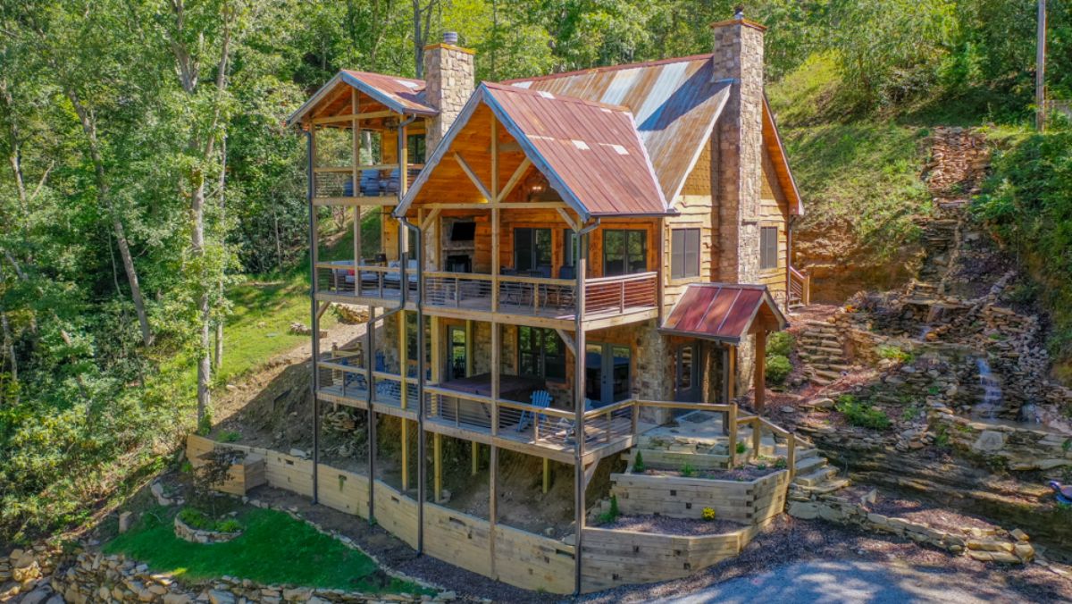 log cabin on hill with multiple covered decks on back