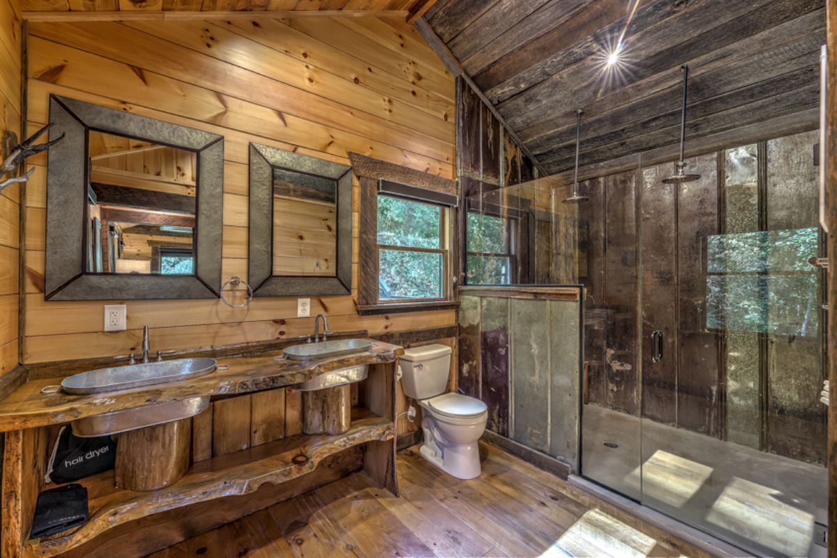 dark wood accents in bathroom with glass door on shower and white toilet