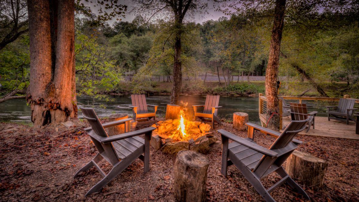 fire pit with Adirondack chairs by lake