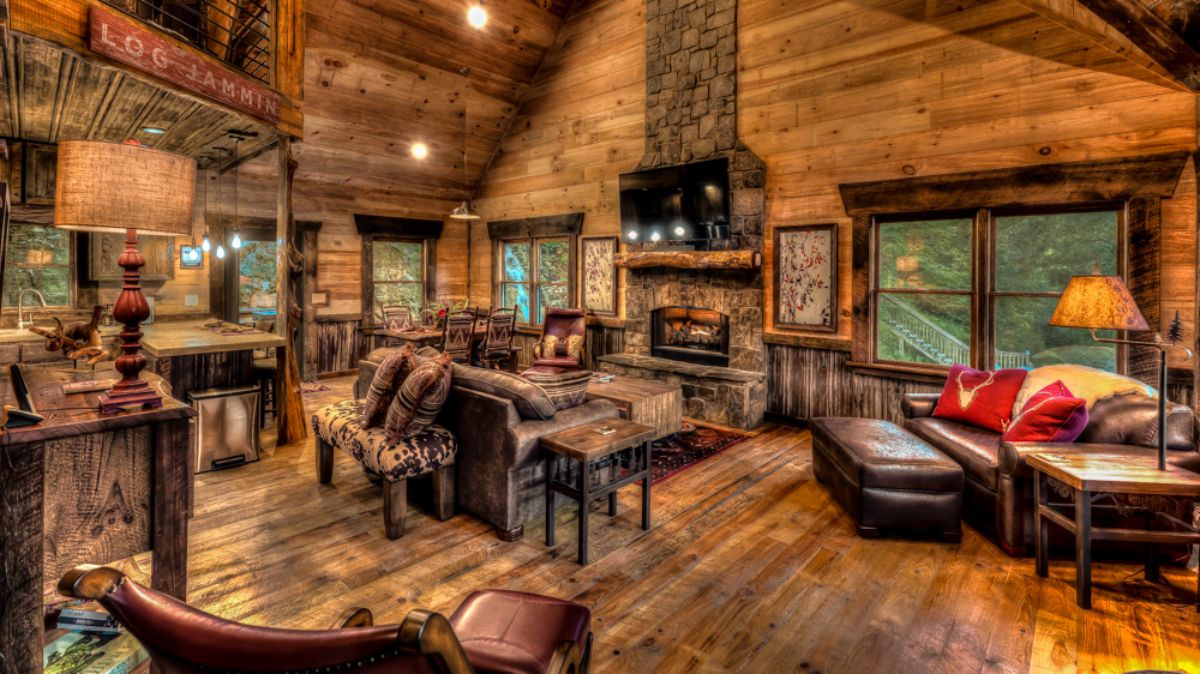 living room of log cabin with fireplace on back wall