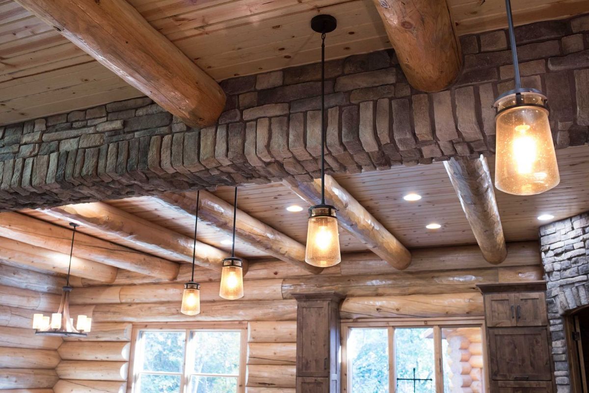 stone covering beam along center of kitchen with dangling lights