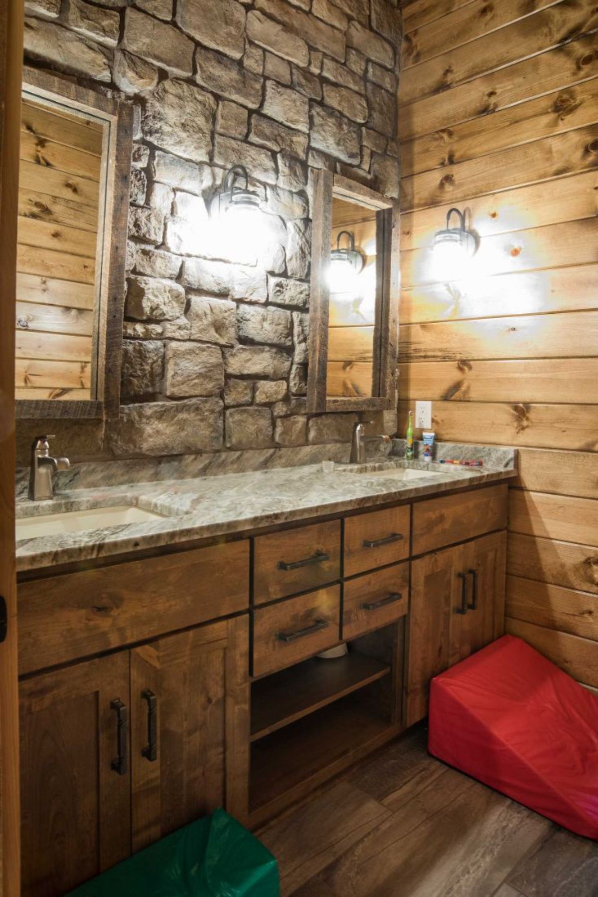 partial stone wall in bathroom of log cabin