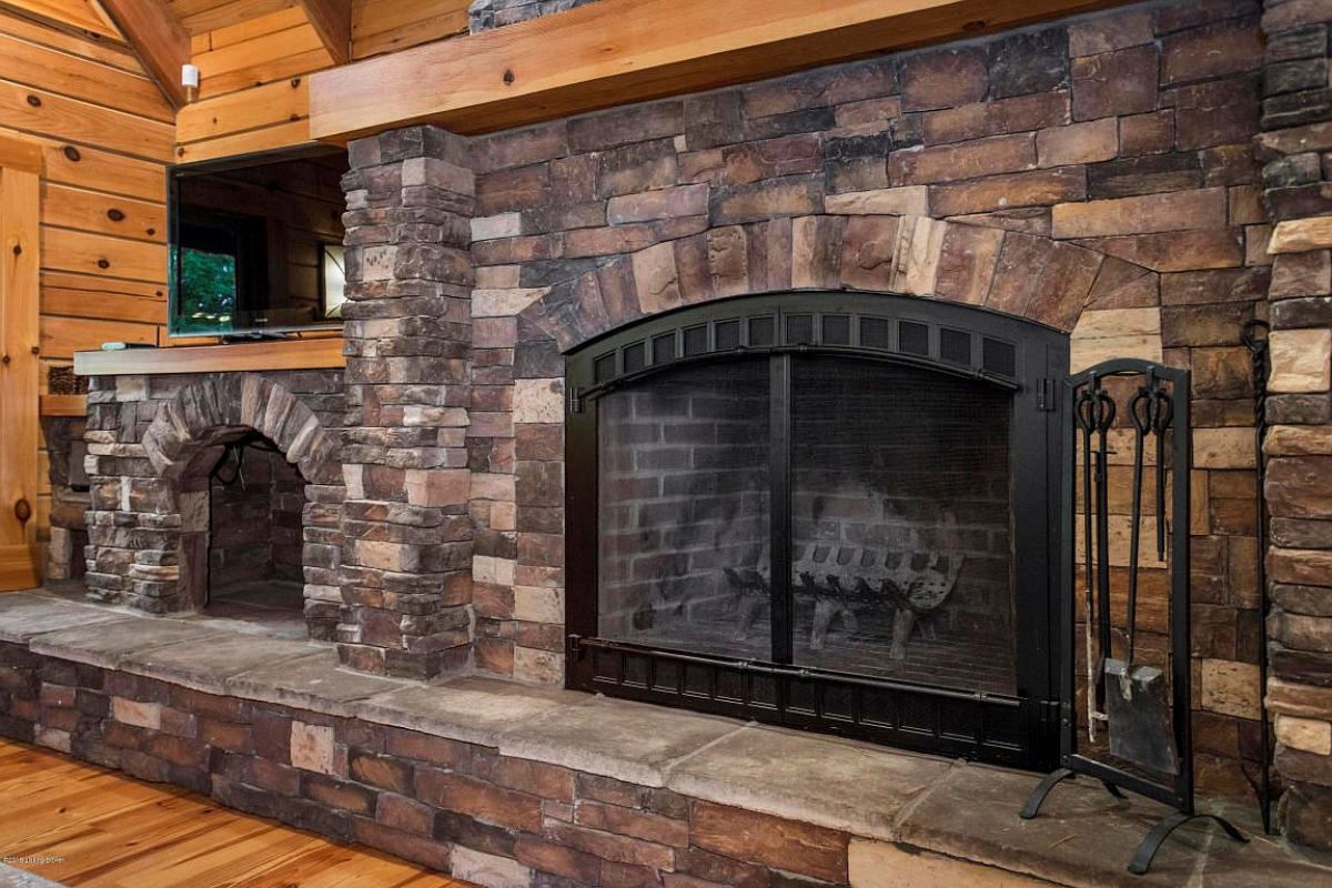 dtone fireplace with wood mantle and black grates