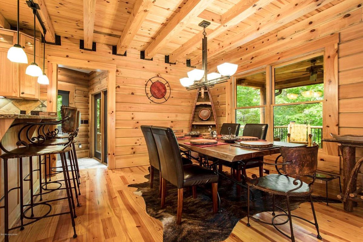 tall back leather chairs at dark wood dining table on top of cowhide rug